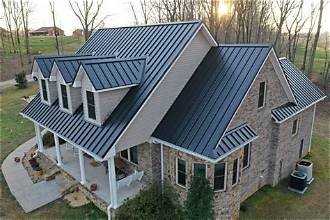 Matte black standing seam metal roof on a farmhouse-style home